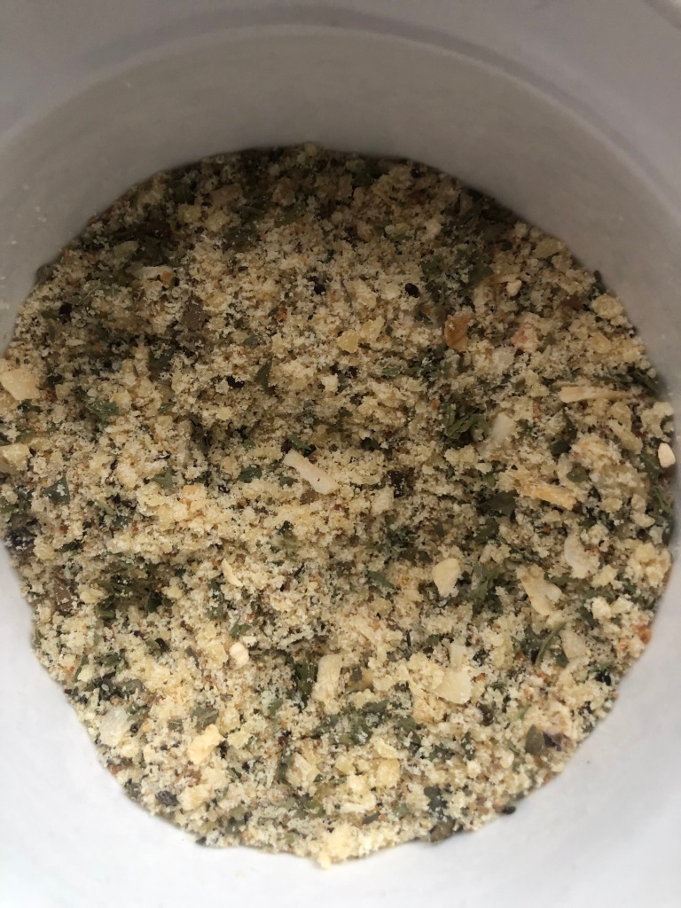 Close up picture of herb and parmesan cheese mix to put on baby potatoes, trimmed asparagus spears and salmon fillets.