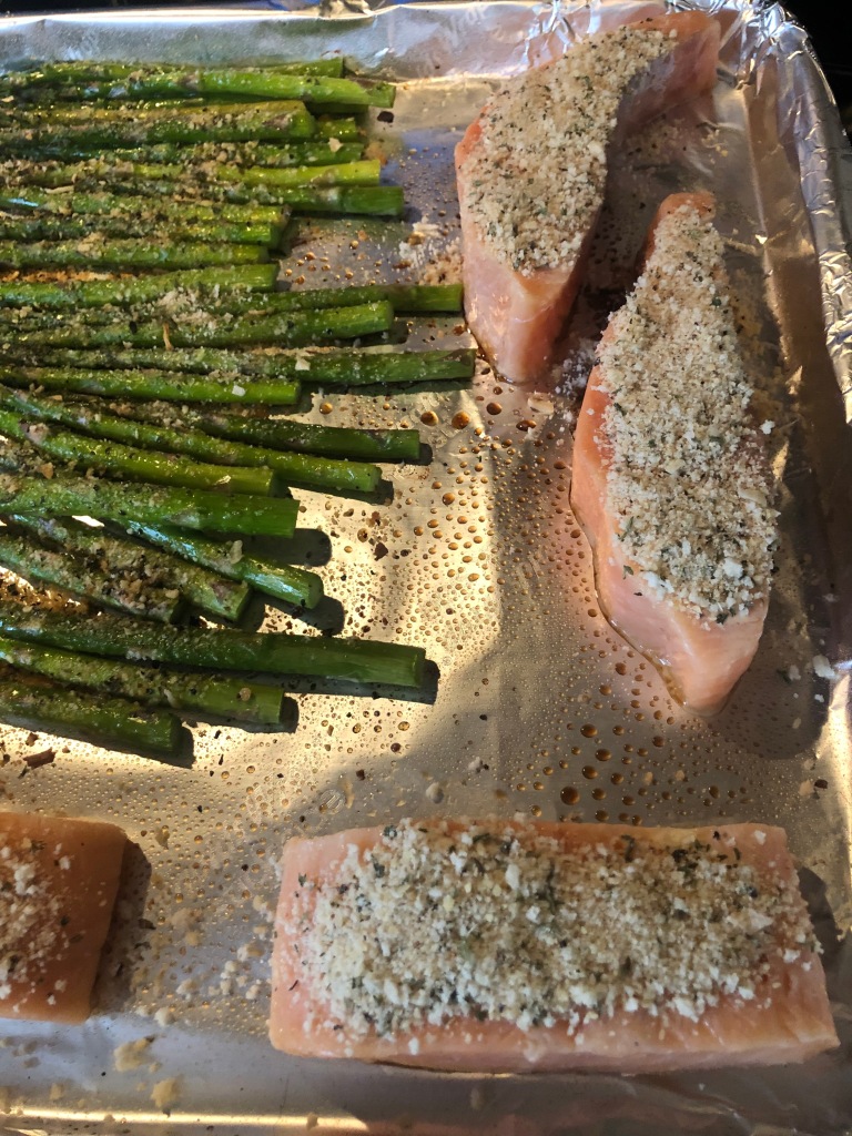 Panko crumb, parmesan and herb mix pressed onto salmon fillets and placed on to foil-covered sheet pan to roast.